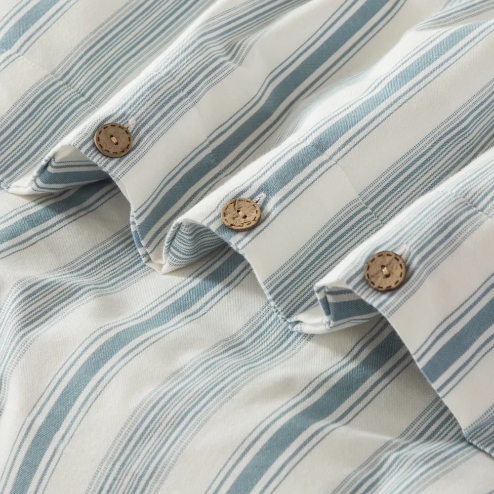 Close-up of blue yarn-dyed cotton stripes with button fastening